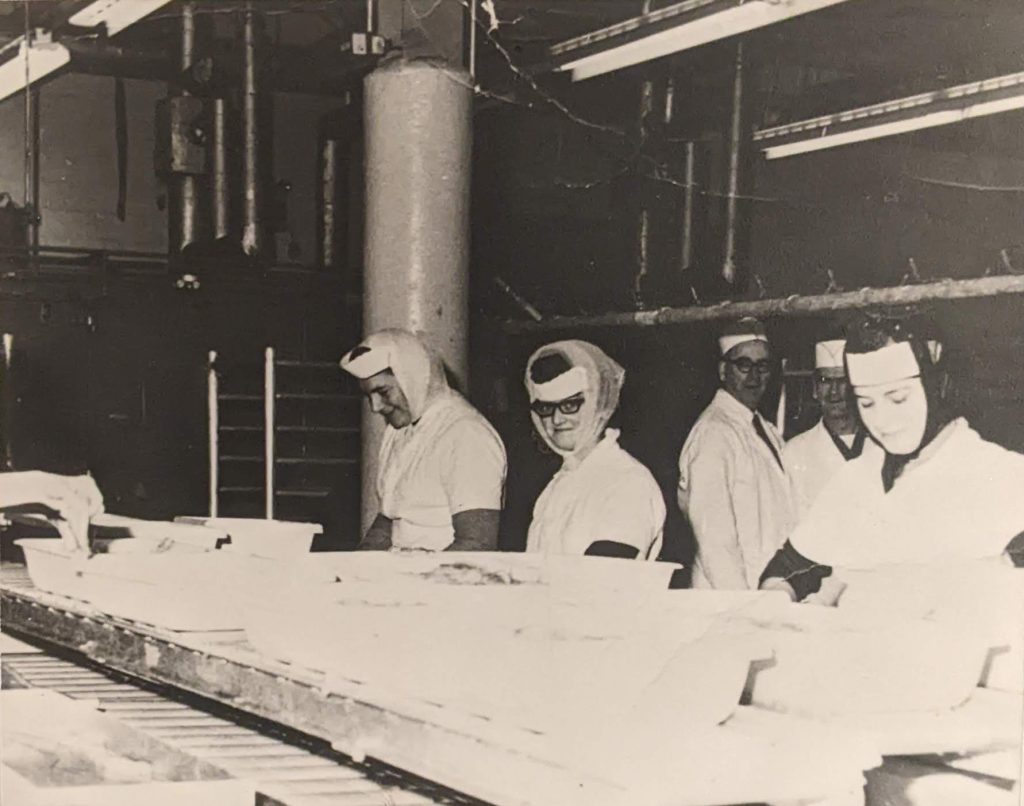 Femmes travaillant à l'intérieur de l'usine de transformation de Paspébiac en 1964. Collection Site historique national de Paspébiac.